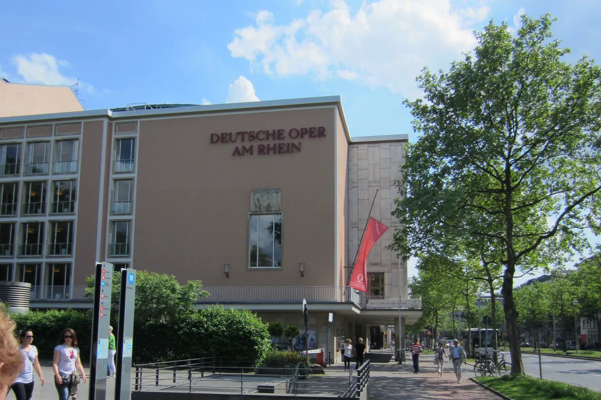 Gebäude der Deutschen Oper am Rhein in Düsseldorf mit Bäumen und Fußweg
